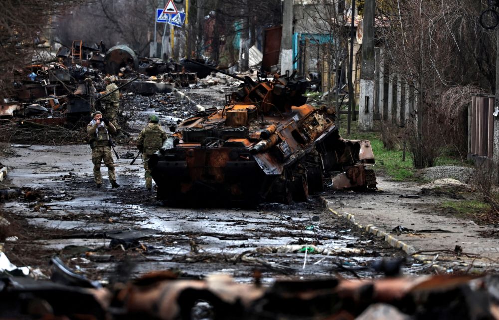 A soldier takes a photograph of his comrade as he poses beside a destroyed Russian tank and armoured vehicles, amid Russiau00e2u20acu2122s invasion on Ukraine in Bucha, in Kyiv region, Ukraine April 2, 2022. u00e2u20acu201d Reuters pic