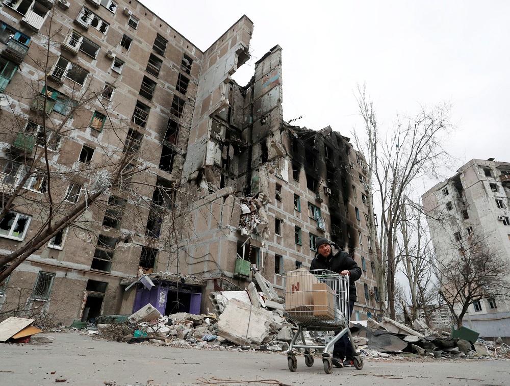 A local resident pushes a cart with humanitarian aid past an apartment building damaged during Ukraine-Russia conflict in the southern port city of Mariupol, Ukraine April 4, 2022. u00e2u20acu2022 Reuters pic