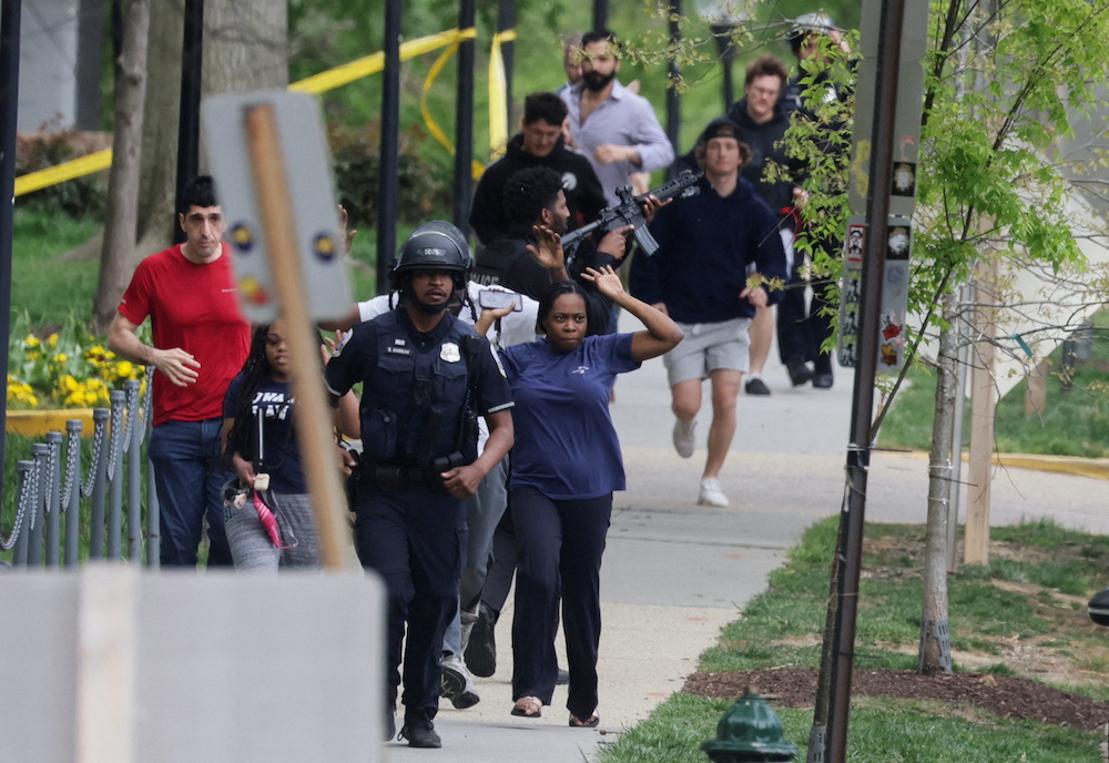 Washington, D.C. Metropolitan Police officers run with civilians at the scene of a reported shooting and active shooter near Edmund Burke Middle School in Northwest Washington, US, April 22, 2022. u00e2u20acu201d Reuters picnn