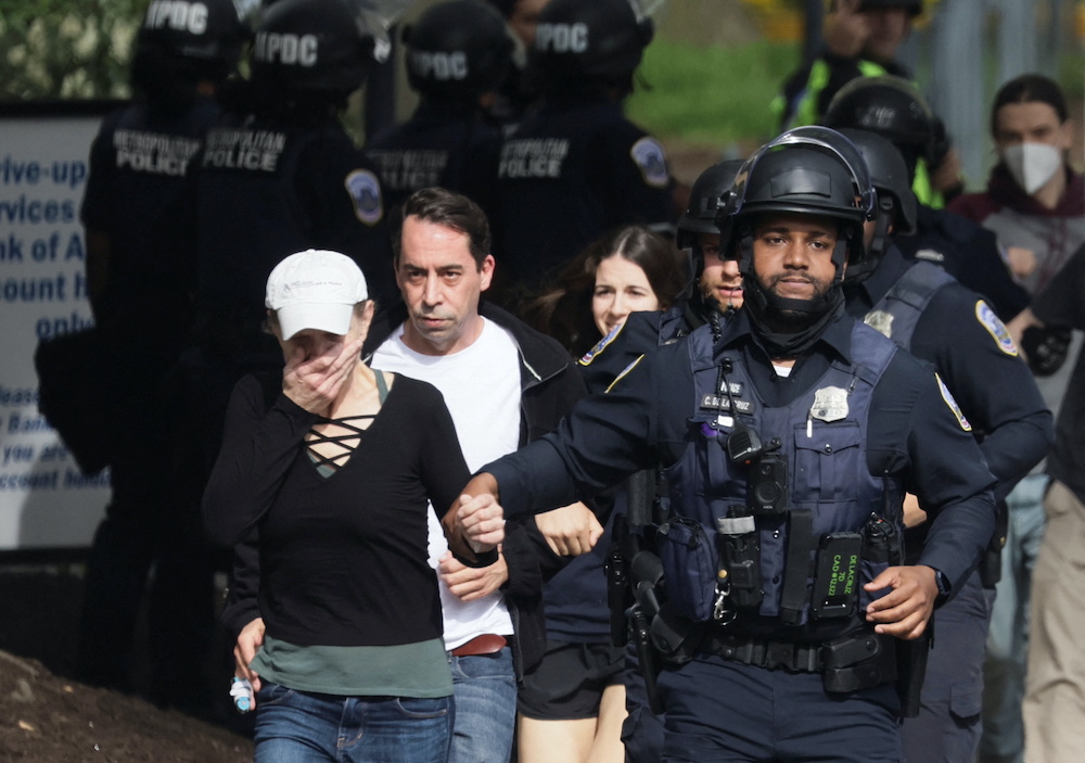 A woman reacts as she runs with Washington, D.C. Metropolitan Police officers and other local residents as police evacuate people to safety at the scene of a reported shooting in Northwest Washington, US, April 22, 2022. u00e2u20acu201d Reuters pic