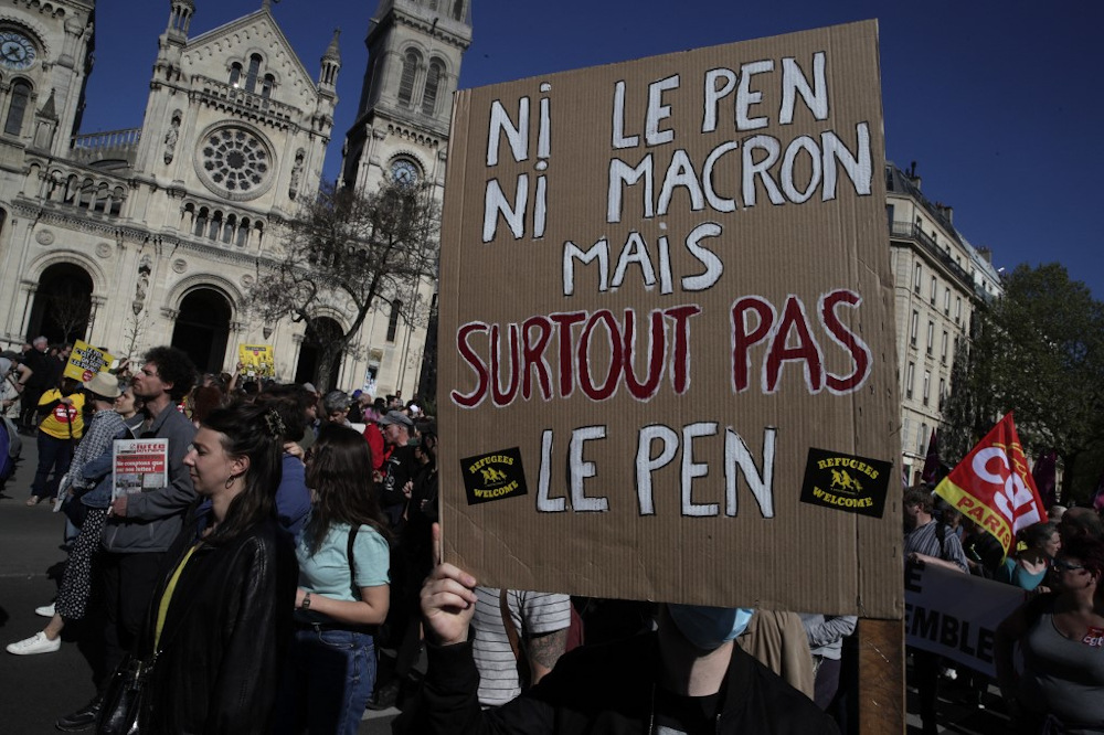 A protestor holds a placard which translates as u00e2u20acu02dcnor Macron, nor Le Pen u00e2u20acu201d not at all Le Penu00e2u20acu2122 during a demonstration u00e2u20acu02dcagainst racism and fascismu00e2u20acu2122 in Paris on April 16, 2022. u00e2u20acu201d AFP pic