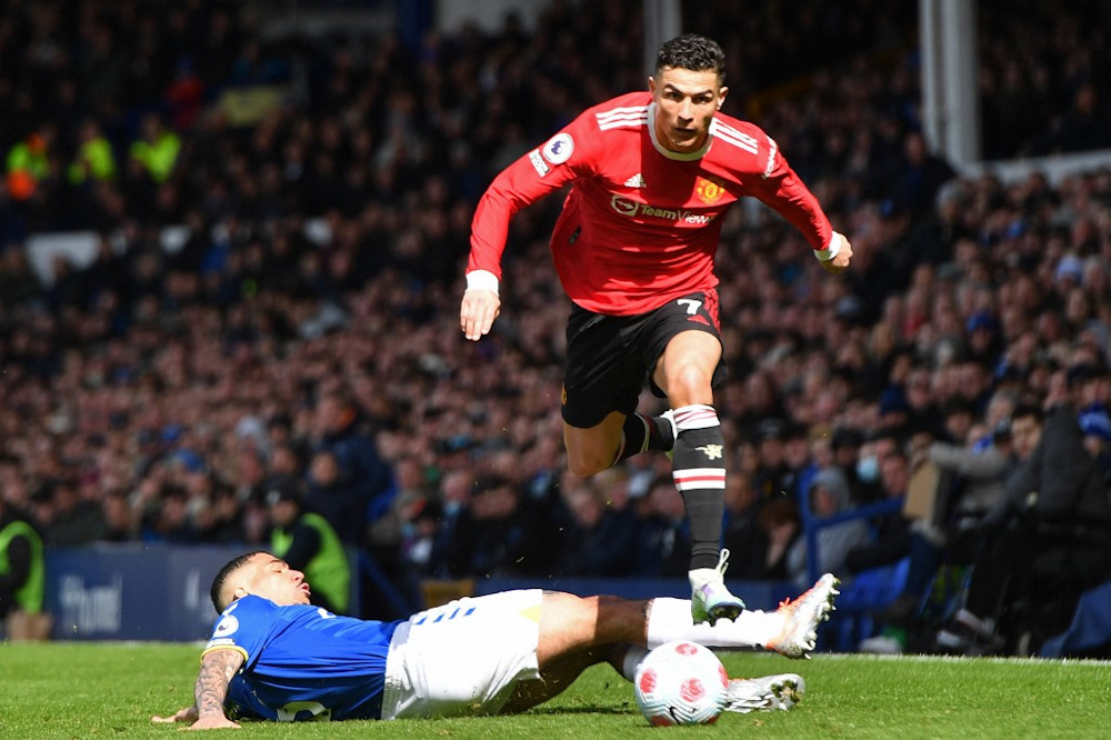 Manchester Unitedu00e2u20acu2122s Portuguese striker Cristiano Ronaldo evades a challenge from Evertonu00e2u20acu2122s Brazilian midfielder Allan during the English Premier League football match between Everton and Manchester United at Goodison Park, Liverpool April 9, 2022. u00e2u20acu201d