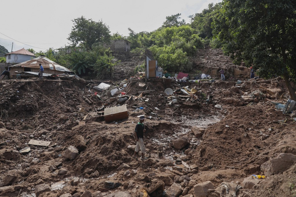 A man walks past the remains of a house at KwaNdengezi township outside Durban on April 15, 2022 where ten people are unaccounted for after their homes were swept away following the devastating rains and flooding. u00e2u20acu201d AFP pic