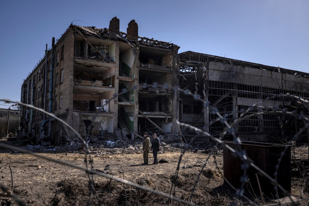 People stand beside damaged buildings at the Vizar company military-industrial complex, after the site was hit by overnight Russian strikes, in the town of Vyshneve, southwestern suburbs of Kyiv, on April 15, 2022.  u00e2u20acu201d AFP pic