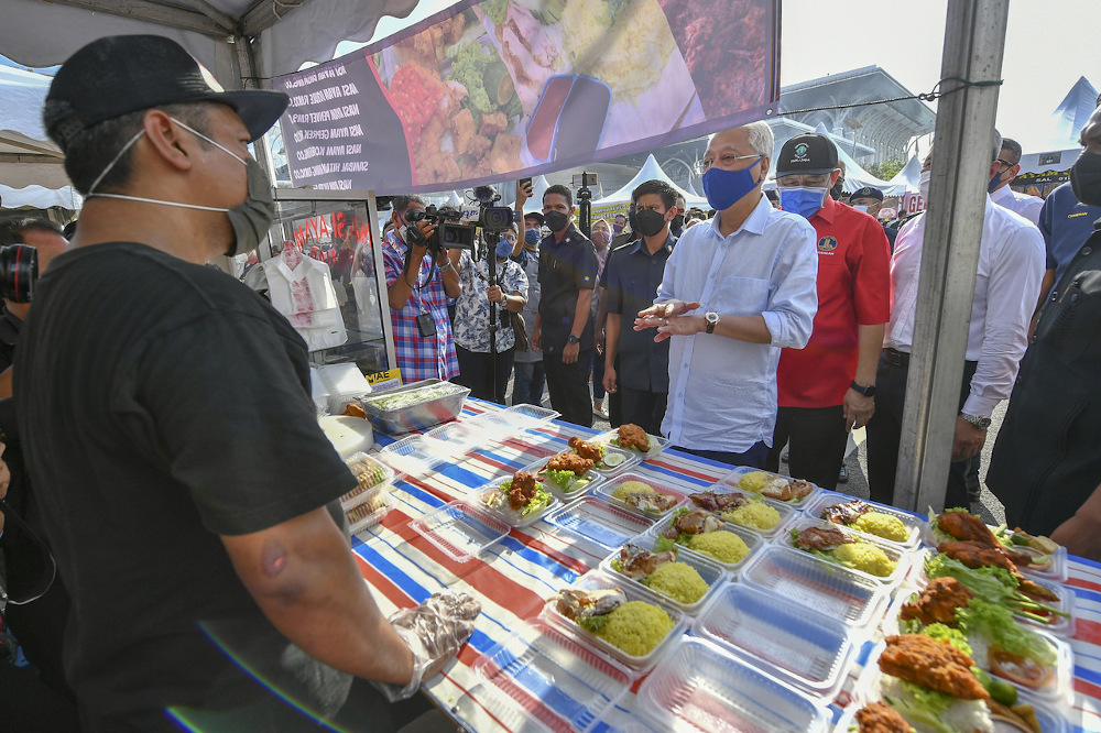 Prime Minister Datuk Seri Ismail Sabri Yaakob speaks to a food vendor while visiting the Ramadan bazaar in Precinct 3 in Putrajaya April 4, 2022. u00e2u20acu201d Bernama pic