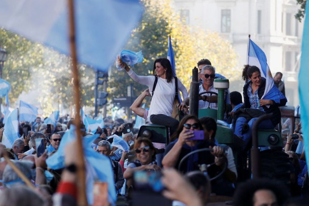People hold Argentine flags as farmers ride tractors at Plaza de Mayo to protest new export taxes on farm goods applied by President Alberto Fernandezu00e2u20acu2122s administration, in Buenos Aires, Argentina April 23, 2022. u00e2u20acu201d Reuters pic