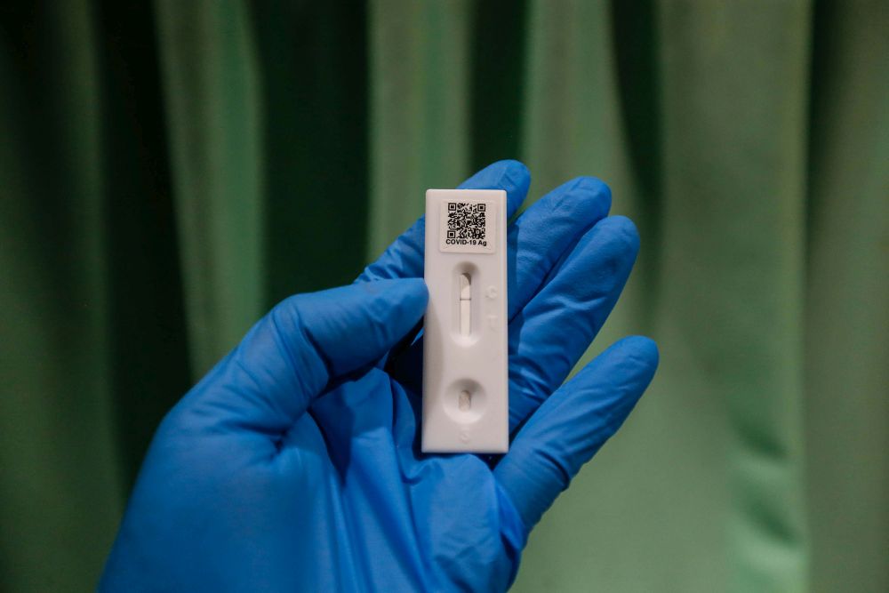A health personnel holds up a Covid-19 test strip indicating a negative result in Seberang Jaya April 7, 2022. u00e2u20acu201d Picture by Sayuti Zainudin