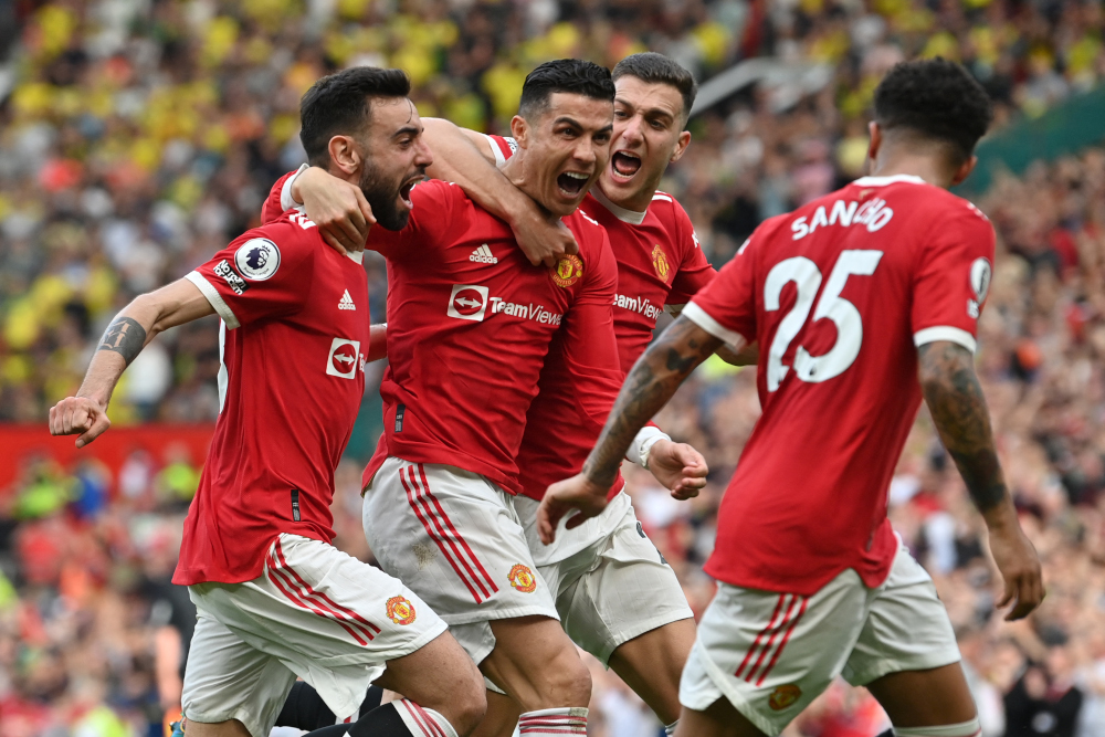 Manchester United striker Cristiano Ronaldo celebrates with teammates after scoring his third goal during the English Premier League match between Manchester United and Norwich City at Old Trafford in Manchester, April 16, 2022. u00e2u20acu201d AFP pic 
