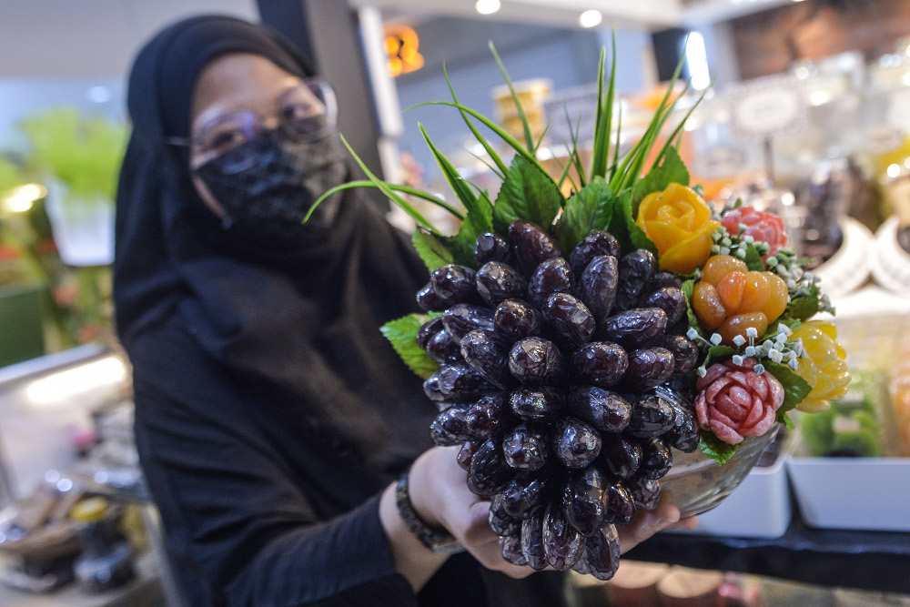 Adira Adipso showing reporters from Malay Mail a sample of Rimbun Serai's 'sunnah' food hampers. — Picture by Miera Zulyana