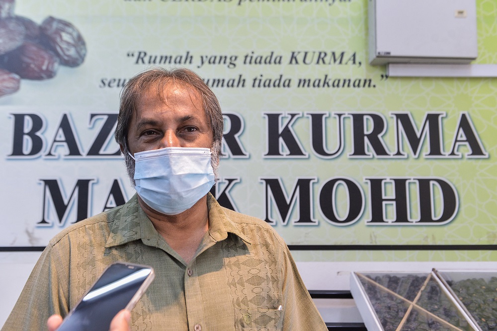 Malik Mohd, owner and proprietor of Bazaar Kurma Malik Mohd in Shah Alam, sharing with Malay Mail that he has been selling dates for over 30 years, seeing it as a business as well as a way to help fellow Muslims perform ‘sunnah’. ― Picture by Miera Zulyana