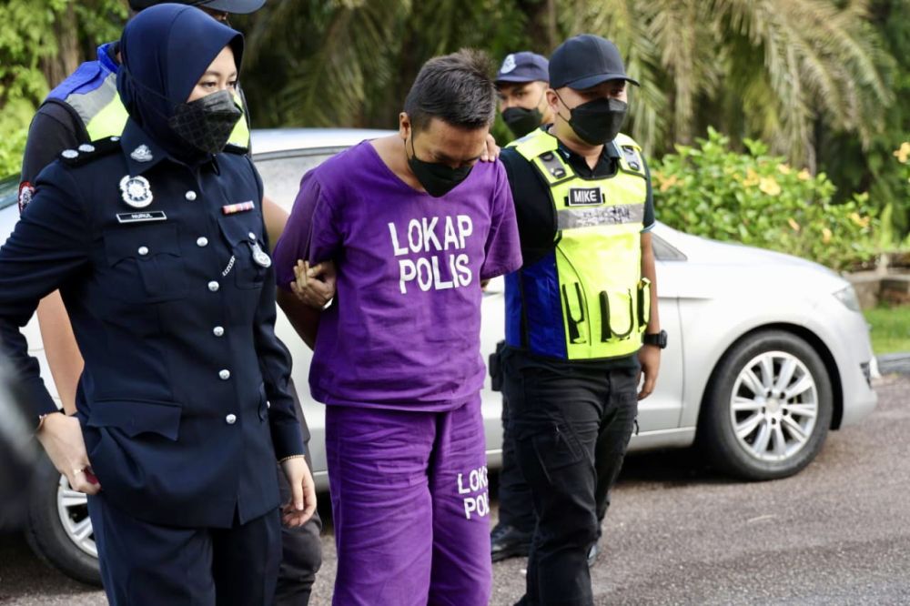 The accused Hadi Hashim is escorted by police at the Kota Tinggi Sessions Court April 26, 2022. u00e2u20acu201d Picture by Ben Tan