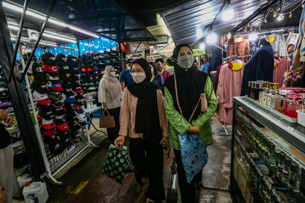 Normala Nordin (right), 55, shops at the Aidilfitri Bazaar on Jalan Tuanku Abdul Rahman, Kuala Lumpur April 27, 2022. — Picture by Hari Anggara