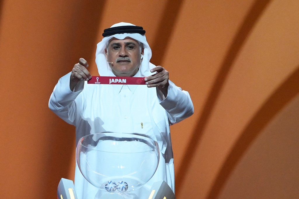 Former Qatari footballer Adel Ahmed MalAllah displays the name of Japan during the draw for the 2022 World Cup in Qatar at the Doha Exhibition and Convention Center on April 1, 2022. u00e2u20acu201d AFP pic