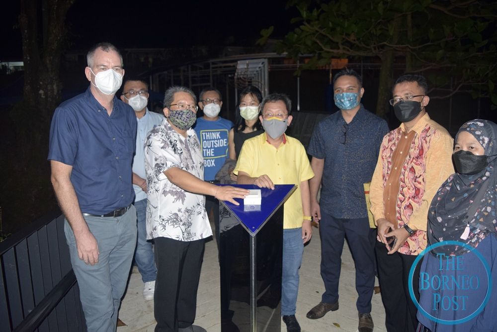 Datuk Seri Dr Sim Kui Hian (front row, 4th right) and Kuching South Mayor Datuk Wee Hong Seng (front row, 2nd left) prepare to push the button to light up the Rainbow Ribbon art installation at Traffic Garden. — Roystein Emmor/Borneo Post pic