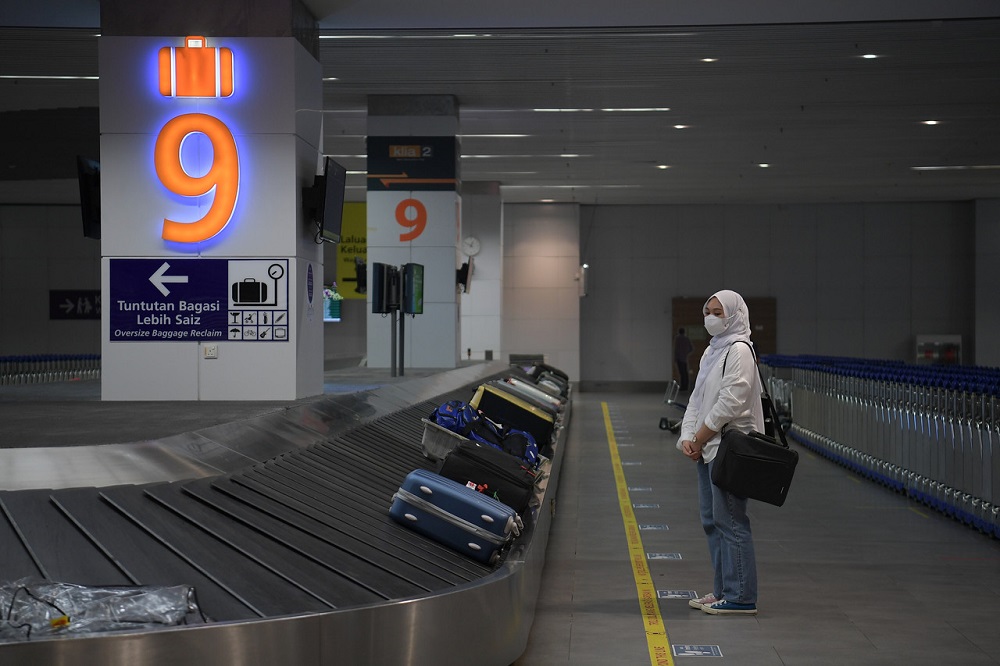 A passenger from Jakarta waits for her luggage after arriving at the Kuala Lumpur International Airport 2 (KLIA2) in Sepang April 1, 2022. u00e2u20acu2022 Bernama pic