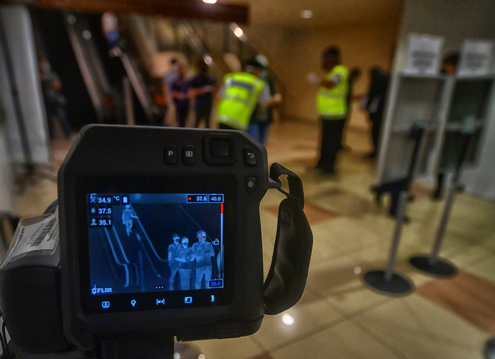 Officers from the Sarawak State Health Department use a body temperature scanner at Kuching International Airport, April 1, 2022. u00e2u20acu201d Bernama pic 