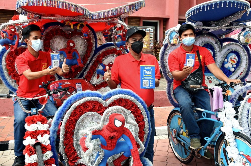 Trishaw pullers Mohd Safwan Aziz, Amran Hashim and Mohd Izwan Taib with their Touch u00e2u20acu02dcn Go e-wallet QR codes at Bandar Hilir, April 18, 2022. u00e2u20acu201d Bernama pic 