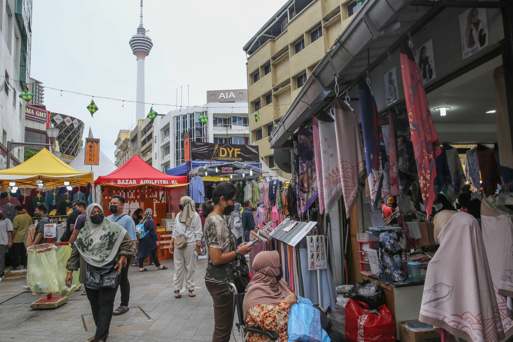People wearing protective face masks shop for the upcoming Hari Raya Aidilfitri celebrations at Jalan Tunku Abdul Rahman in Kuala Lumpur, April 21, 2022. u00e2u20acu201d Picture by Yusof Mat Isa