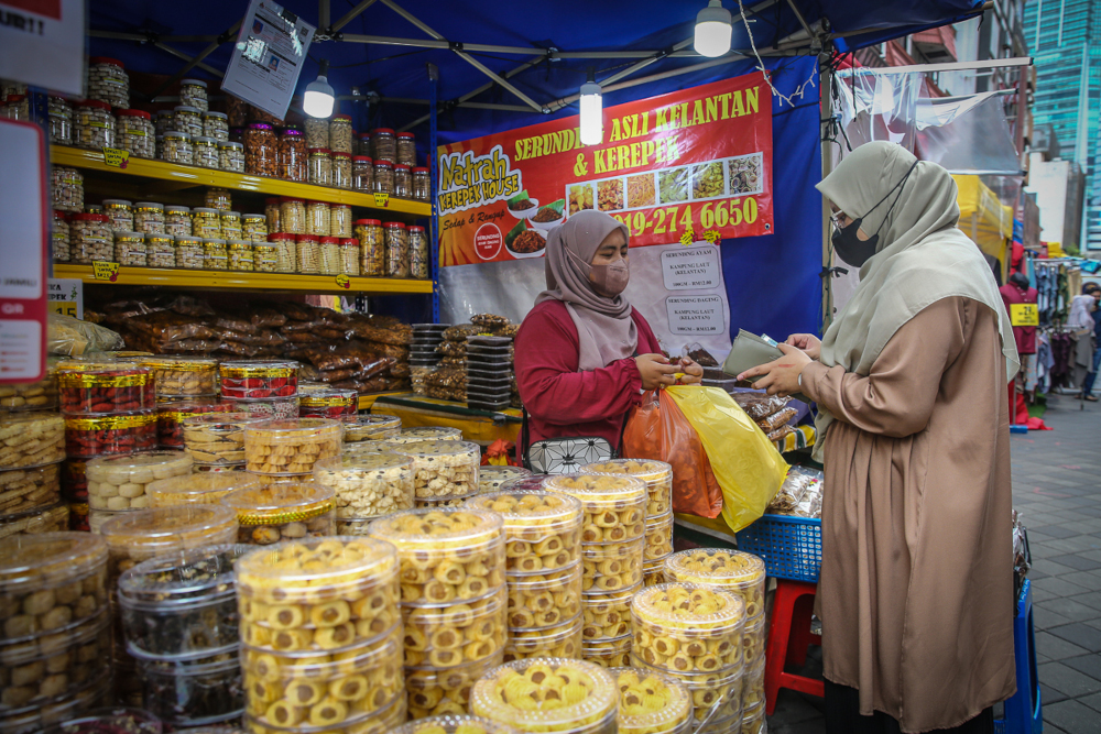 People wearing protective face masks shop for the upcoming Hari Raya Aidilfitri celebrations at Jalan Tunku Abdul Rahman in Kuala Lumpur, April 21, 2022. u00e2u20acu201d Picture by Yusof Mat Isa