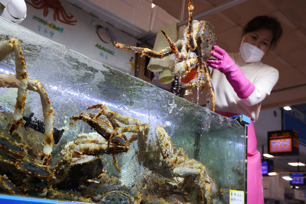 Kim Mi-kyeong, a shopkeeper, shows a king crab imported from Russia to a customer at Noryangjin Fisheries Wholesale Market in Seoul April 8, 2022. u00e2u20acu201d Reuters pic