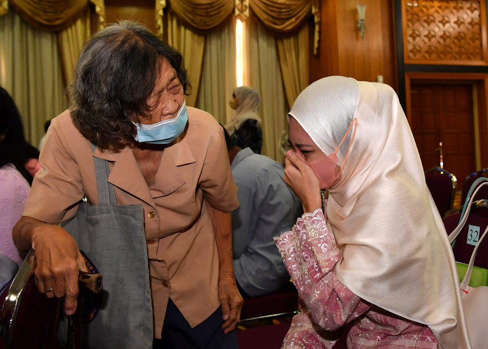 Rohana Abdullah sheds tears of joy while watched by her adoptive mother Chee Hoi Lan, after she was granted Malaysian citizenship status from Home Minister Datuk Seri Hamzah Zainudin in Putrajaya, April 29, 2022. u00e2u20acu201d Bernama pic 
