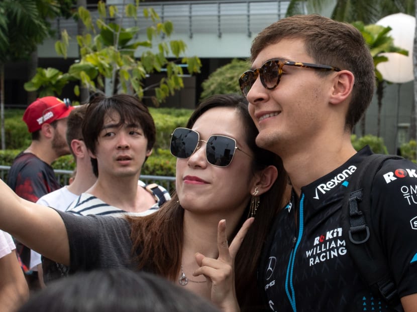 British driver George Russell (far right) posing for a photo with fans when he was in Singapore for the Formula One night race in September 2019. He is one of the hottest to-watch drivers, now racing with Mercedes in the 2022 season. u00e2u20acu2022 AFP pic