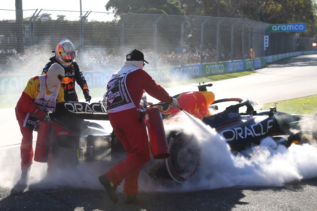 Marshalls try to extinguish fire as Red Bullu00e2u20acu2122s Dutch driver Max Verstappen (second left) looks at his car during the 2022 Formula One Australian Grand Prix at the Albert Park Circuit in Melbourne on April 10, 2022. u00e2u20acu201d AFP pic