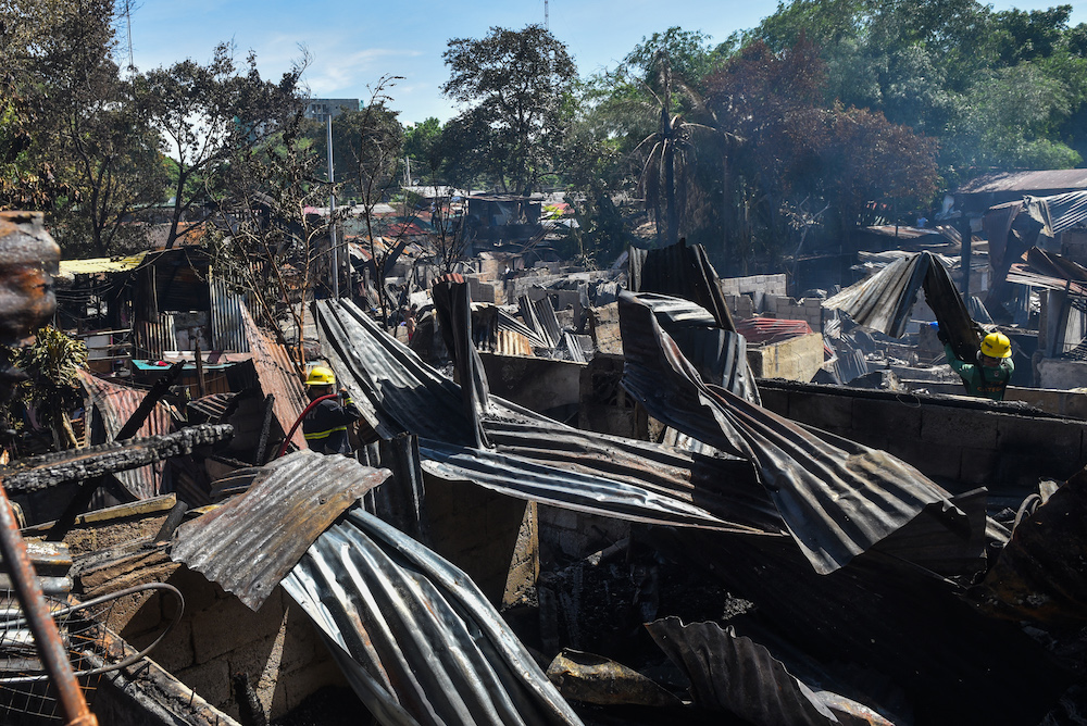 Firemen work at the scene of a fire at an informal settlement inside the campus of the University of the Philippines in Quezon City May 2, 2022. u00e2u20acu201d AFP pic