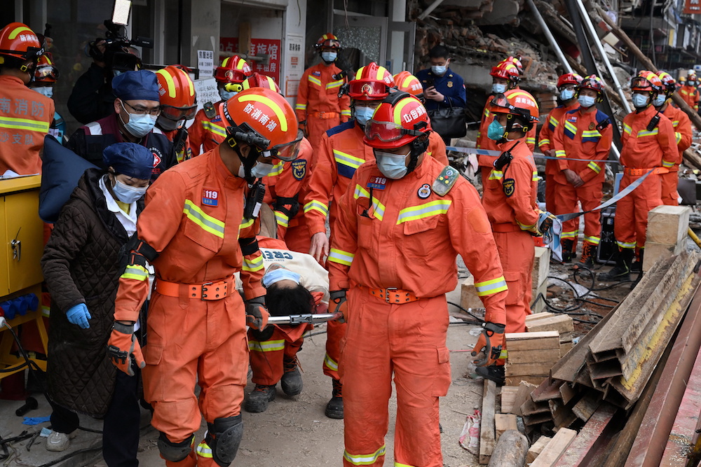 Rescue workers carry an injured person on a stretcher at a site where a building collapsed in Changsha, Hunan province, China May 1, 2022. u00e2u20acu201d China Daily pic via Reuters