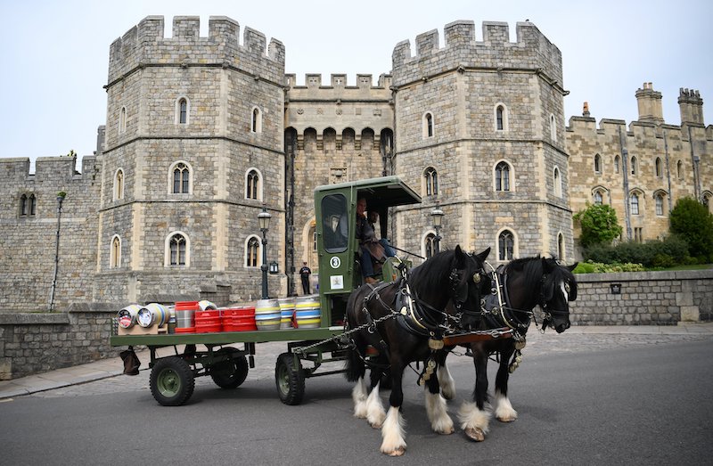 A horse-drawn drives in front of Windsor Castle, the residence of Queen Elizabeth II, as they deliver to pubs different beers made by Windsor & Eton Brewery in Windsor, England on April 28, 2022. u00e2u20acu201d AFP pic