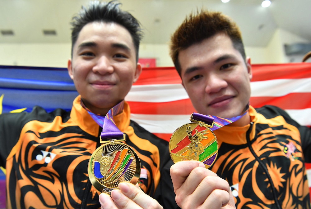 National wushu athletes Tan Zhi Yan (left) and Clemet Ting Su Wei celebrate their gold medal win in the Taijiquan and Changquan events at the 31st SEA Games in Hanoi, May 13, 2022. u00e2u20acu201d Bernama pic