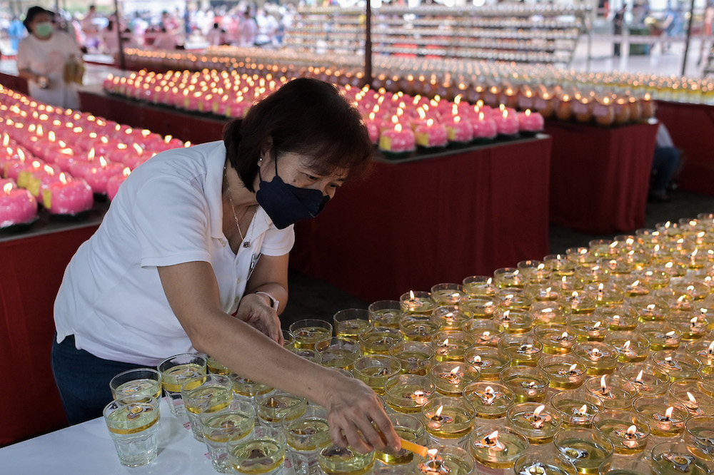A devotee lights a candle on Wesak Day at the Maha Vihara temple in Brickfields May 15,2022. u00e2u20acu201d Picture by Miera Zulyana