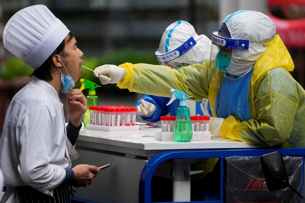 A medical worker in a protective suit collects a swab sample from a chef for nucleic acid testing, during lockdown, amid the coronavirus disease pandemic in Shanghai May 13, 2022. u00e2u20acu201d Reuters pic