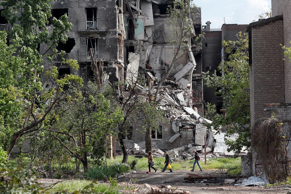 People walk past a residential building heavily damaged during Ukraine-Russia conflict in the southern port city of Mariupol, Ukraine May 15, 2022. u00e2u20acu201d Reuters pic
