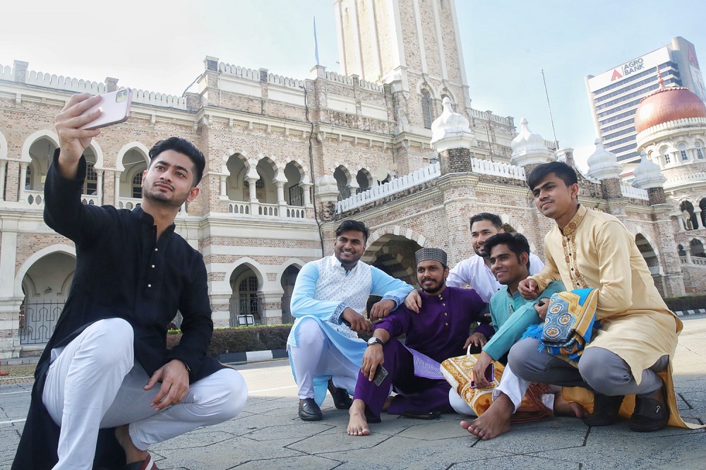 People pose for pictures on the first day of Hari Raya at Dataran Merdeka in Kuala Lumpur May 2, 2022. — Picture by Choo Choy May