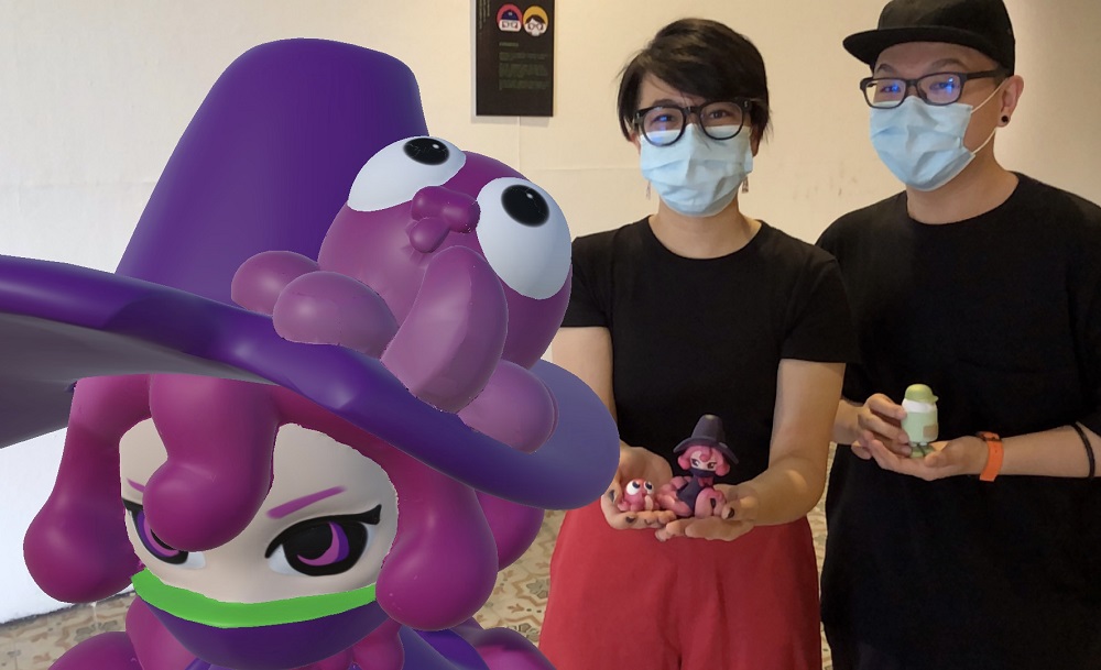 Kamaboko’s duo, Julia Wee (left) and Darrel Cheong, holding the actual toys posing next to their AR toy. 