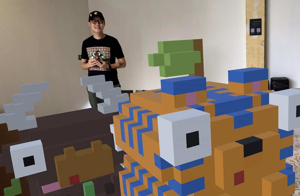 Edward Low or Drawdelow, holding the Bullshit toy while posing with the pixel art AR toys.