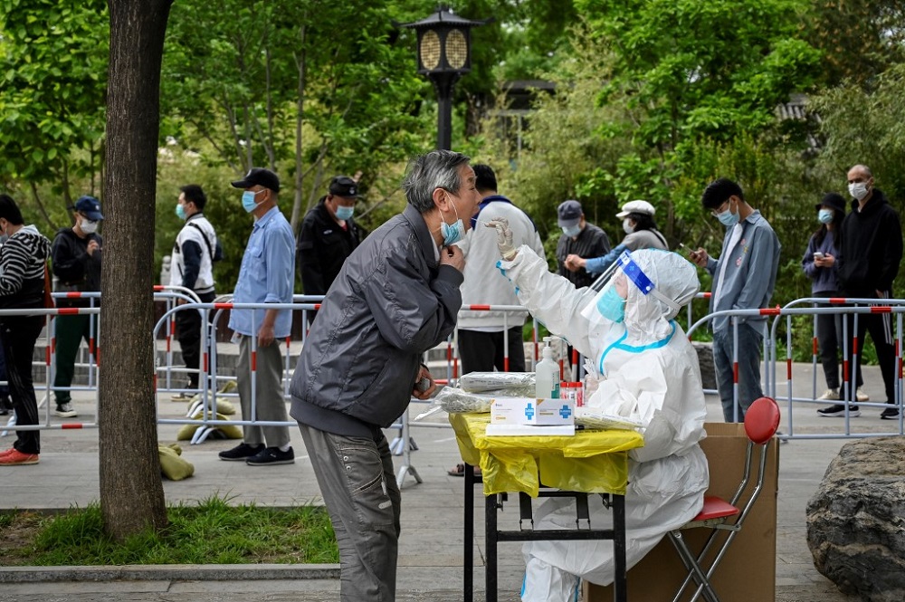 A health worker takes a swab sample from a man to be tested for Covid-19 coronavirus at a makeshift testing site along a street in Beijing May 7, 2022. u00e2u20acu201d AFP pic