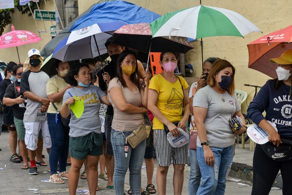 People queue before casting their votes during the presidential election at a polling station in Manila May 9, 2022. — AFP pic