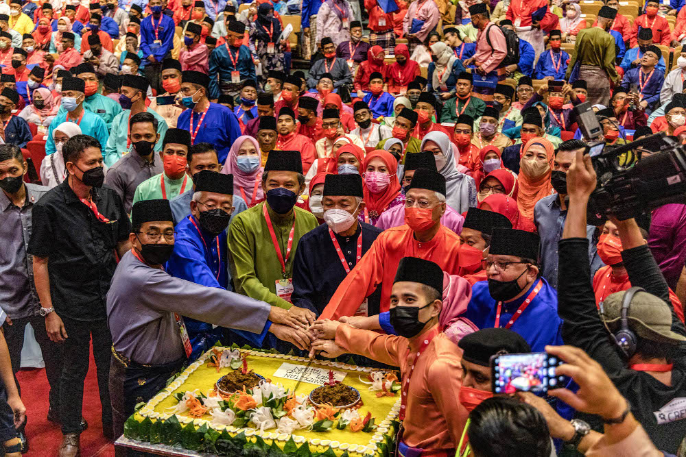 Umno president Datuk Seri Ahmad Zahid Hamidi with other party leaders cut a Malay traditional u00e2u20acu02dcpulut kuningu00e2u20acu2122 cake in conjunction with Umnou00e2u20acu2122s 76th anniversary at the World Trade Centre in Kuala Lumpur May 15, 2022. u00e2u20acu201d Picture by Firdaus Latif