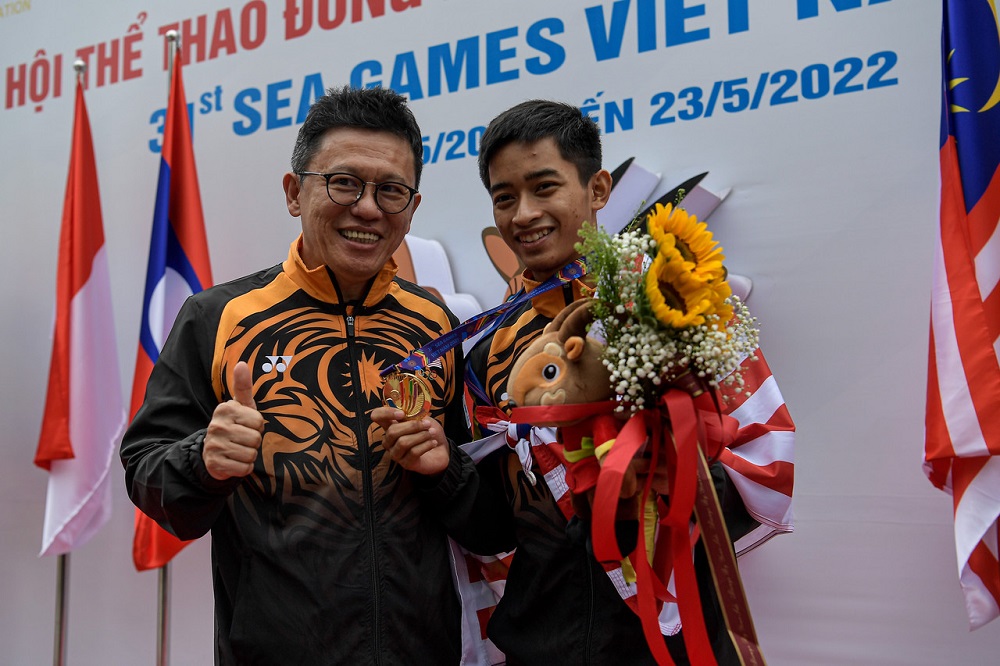 Deputy Youth and Sports Minister Ti Lian Ker (left) poses with gold medallist Muhammad Khairi Adib Azhar following his win at the pencak silat match at the SEA Games in Hanoi May 16, 2022. u00e2u20acu201d Bernama pic