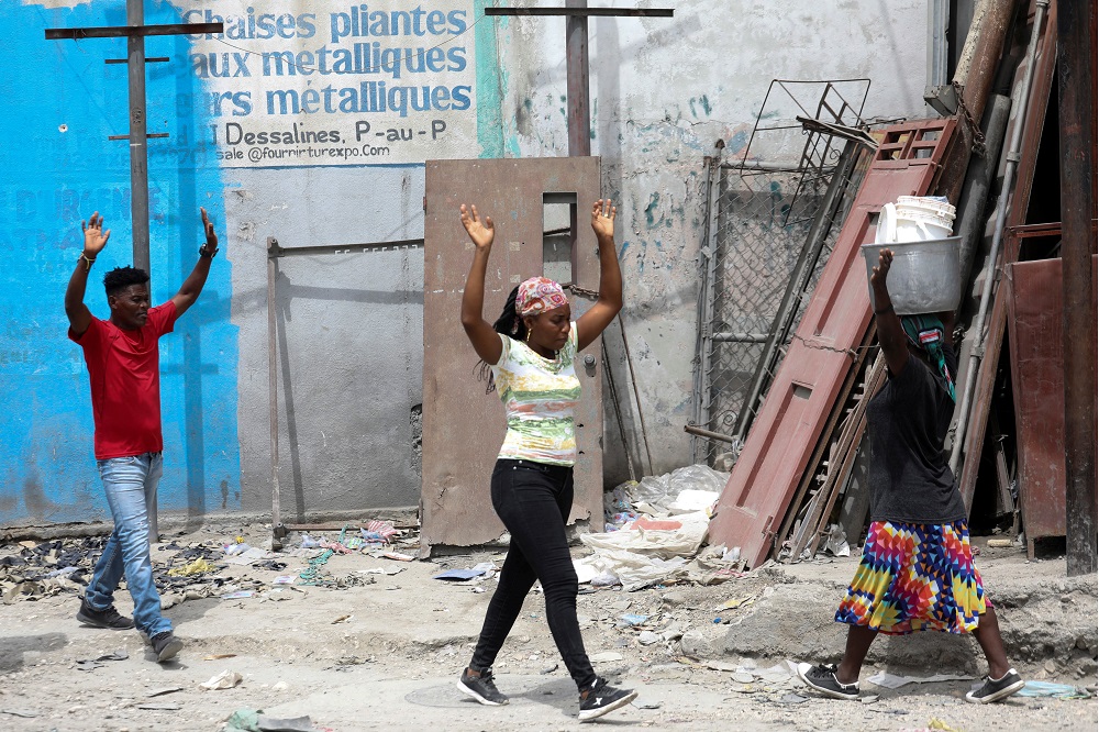 Residents raise their arms as they flee their homes due to ongoing gun battles between rival gangs, in Port-au-Prince, Haiti May 2, 2022. u00e2u20acu2022 Reuters pic