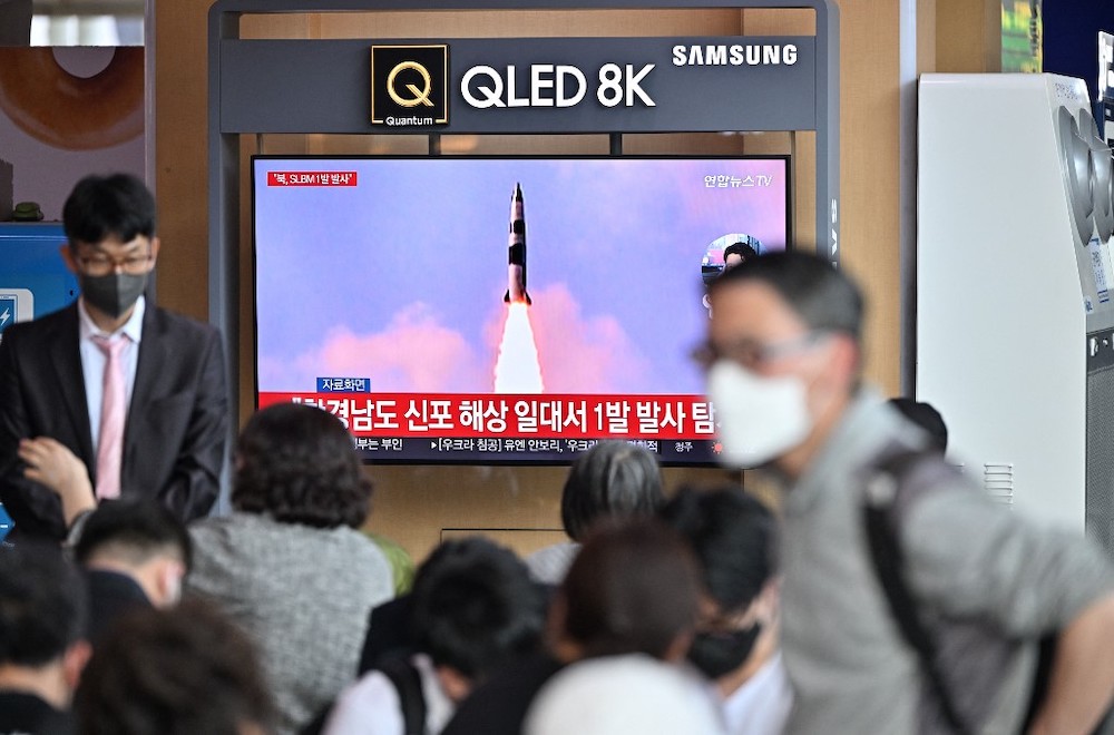 People watch a television screen showing a news broadcast with file footage of a North Korean missile test, at a railway station in Seoul on May 7, 2022, after North Korea fired a submarine-launched ballistic missile according to South Koreau00e2u20acu2122s military.