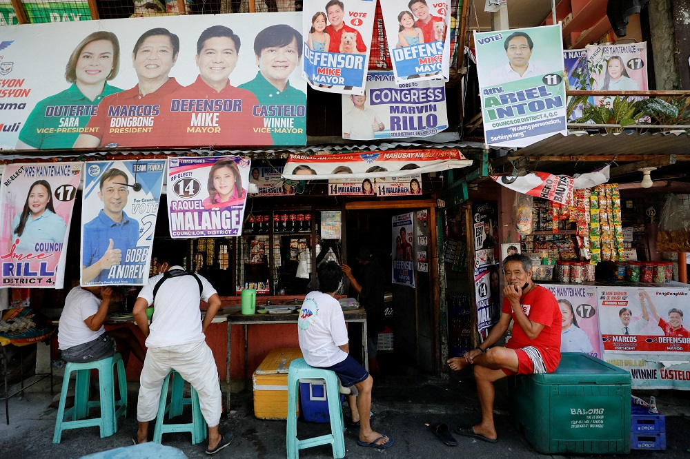 Residents sit at a stall with election campaign posters for the 2022 Philippine elections in Quezon City, Metro Manila, Philippines May 7, 2022. u00e2u20acu2022 Reuters pic