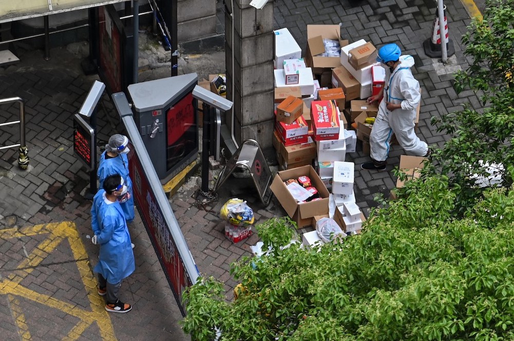 A delivery worker delivers boxes at the entrance of a building during a Covid-19 coronavirus lockdown in the Jingu00e2u20acu2122an district in Shanghai on April 30, 2022. u00e2u20acu201d AFP pic