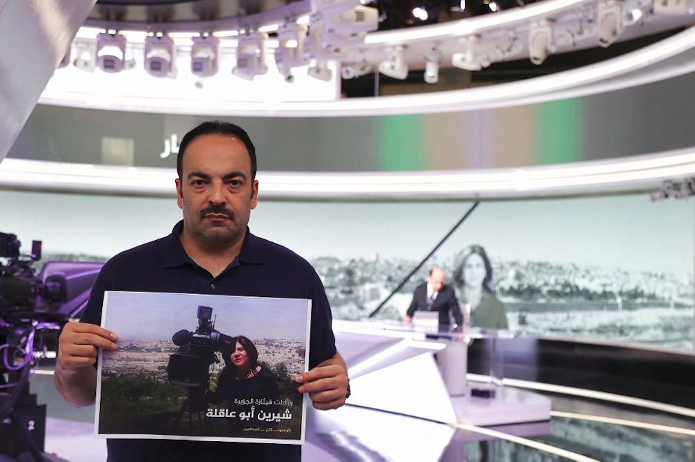 Al Jazeera journalist Haitham Abu Saleh stands holding a sign mourning the death of his colleague Shireen Abu Aqleh, who was killed while covering an Israeli army raid on Jenin refugee camp in the occupied West Bank, in Doha May 11, 2022. u00e2u20acu201d AFP pic