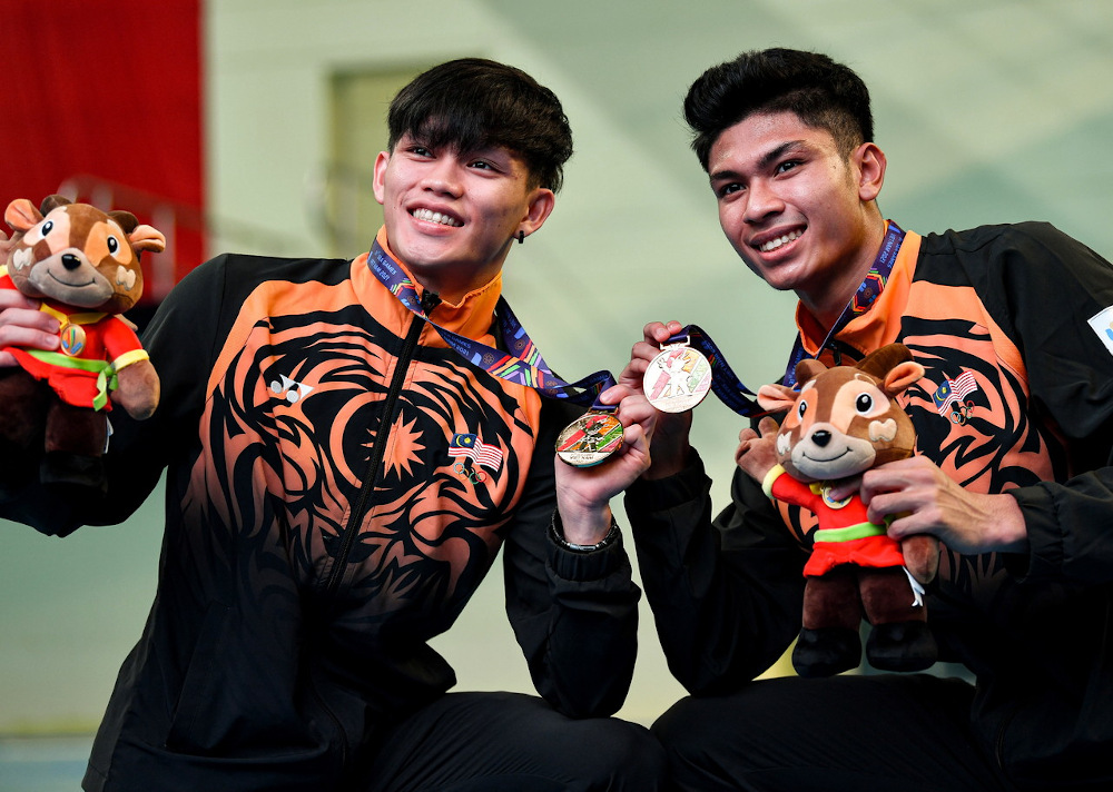 Malaysian divers Jellson Jabilli (left) and Hanis Nazirul Jaya Surya (right) pose with their gold medals after winning the menu00e2u20acu2122s synchronised 10m platform at the 31st SEA Games in My Dinh Aquatic Centre, Hanoi May 10, 2022. u00e2u20acu201d Bernama pic