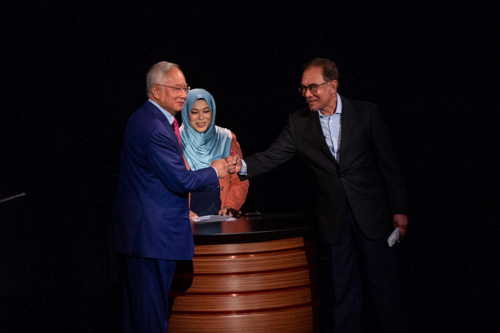 Datuk Seri Anwar Ibrahim and Datuk Seri Najib Razak bump fists before the start of the Debat Perdana at Matic, Kuala Lumpur, May 12, 2022. u00e2u20acu201d Picture by Shafwan Zaidon