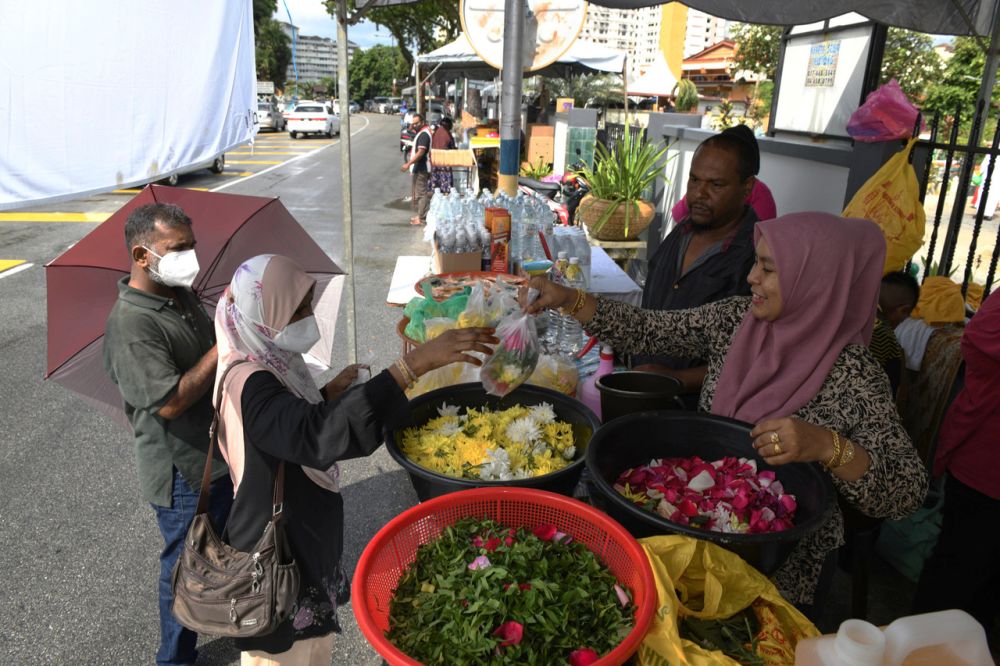 Visitors to the Jalan Perak Muslim Cemetery buy fresh flowers from Rosinah  in George Town May 3, 2022. u00e2u20acu201d Bernama picnn