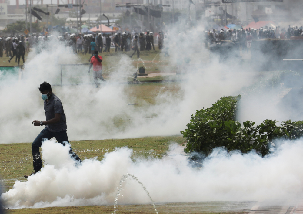 Supporters of Sri Lankau00e2u20acu2122s ruling party run as riot police fire tear gas during a clash with anti-government demonstrators, amid the countryu00e2u20acu2122s economic crisis, in Colombo May 9, 2022. u00e2u20acu201d Reuters pic